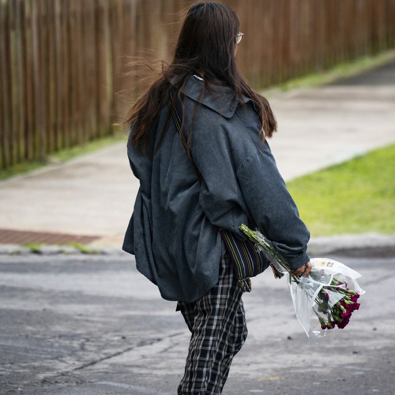 A girl carries flowers during a vigil for 13-year-old Nyah Mway in Utica, N.Y., Saturday, June 29, 2024. On Friday, June 28, Mway was fatally shot by police who’d tackled him to the ground after he allegedly pointed what turned out to be a BB gun at them during a foot chase. (Daniel DeLoach/Observer-Dispatch via AP)