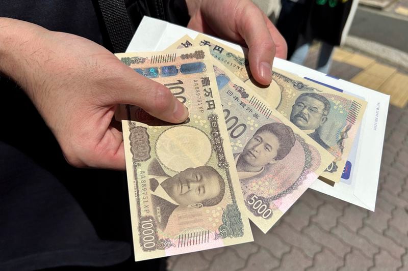 A person shows new 10,000, 5,000 and 1,000 Yen banknotes after he withdrew bills from a ATM machine at a bank Wednesday, July 3, 2024, in Tokyo. Japan issued its first new bills in two decades Wednesday, packed with 3-D hologram technology to fight counterfeiting. Newly designed banknotes, 10,000 yen (about US$61), 5,000 yen (about US$30) and 1,000 yen (about US$6) went into circulation Wednesday. (AP Photo/Ayaka McGill)