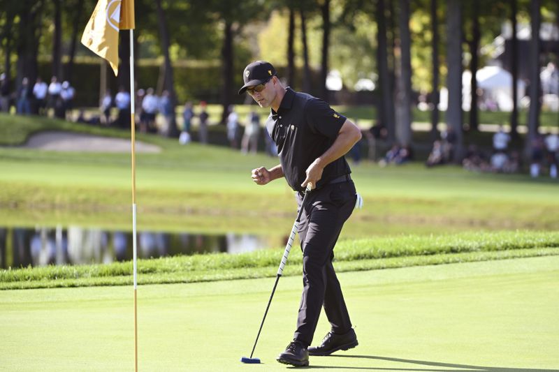 International team member Adam Scott of Australia, makes a putt on the 10th green during a foursome match at the Presidents Cup golf tournament at the Royal Montreal Golf Club in Montreal, Friday, Sept. 27, 2024. (Graham Hughes/The Canadian Press via AP)