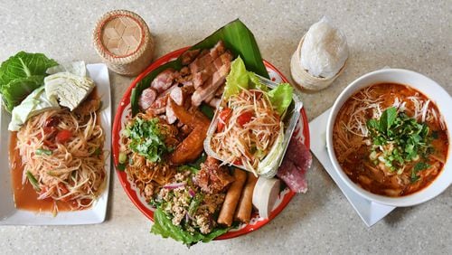Among the dishes served at Snackboxe Bistro in Duluth are, from left, tham mak hoong (papaya salad), Lao platter and khao poon (red curry noodle soup). Food styling by Vanh Sengaphone and Thip Athakhanh. (CHRIS HUNT FOR THE ATLANTA JOURNAL-CONSTITUTION)
