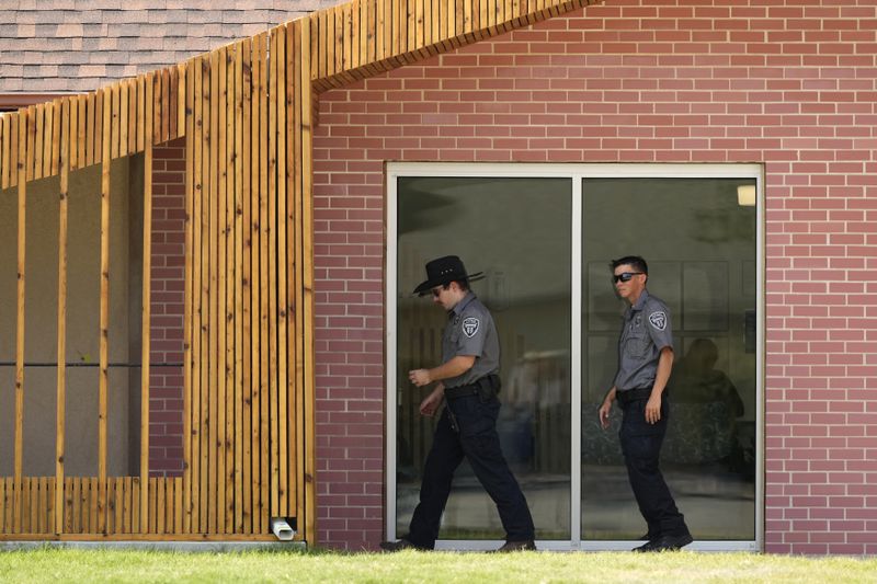 Security personnel stand outside a recently opened Planned Parenthood clinic, Tuesday, Sept. 10, 2024, in Pittsburg, Kan. (AP Photo/Charlie Riedel)