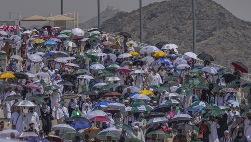 Muslim pilgrims use umbrellas to shield themselves from the sun as they arrive to cast stones at pillars in the symbolic stoning of the devil, the last rite of the annual hajj, in Mina, near the holy city of Mecca, Saudi Arabia, Tuesday, June 18, 2024. Muslim pilgrims were wrapping up the Hajj pilgrimage in the deadly summer heat on Tuesday with the third day of the symbolic stoning of the devil, and the farewell circling around Kaaba in Mecca's Grand Mosque. (AP Photo/Rafiq Maqbool)