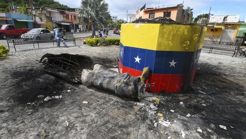 A destroyed statue of the late Venezuelan President Hugo Chavez lays next to its base in Valencia, Venezuela, Tuesday, July 31, 2024, the day after people protested the official election results that certified Chavez's protege, current President Nicolas Maduro, as the winner. (AP Photo/Jacinto Oliveros)