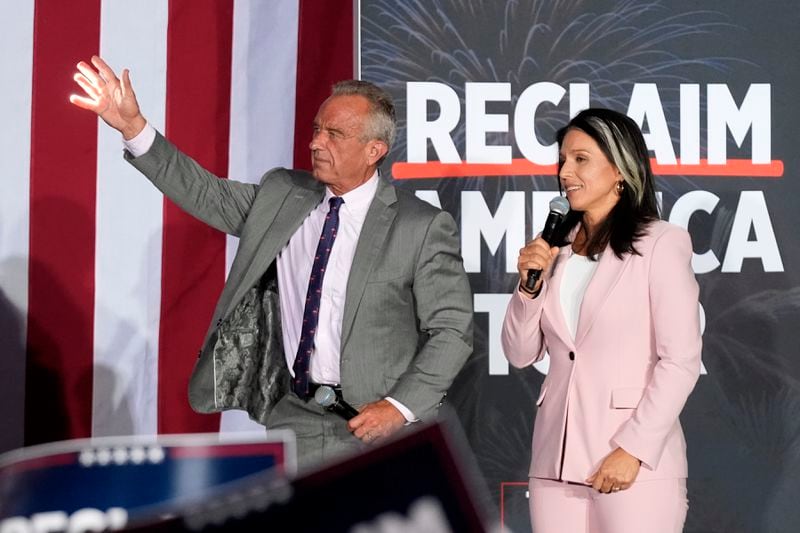 Former Independent candidate for president Robert F. Kennedy, Jr., left, waves to the crowd as former Democratic Rep. Tulsi Gabbard speaks during a campaign event for Republican presidential nominee former President Donald Trump, Saturday, Sept. 14, 2024, in Glendale, Ariz. (AP Photo/Ross D. Franklin)