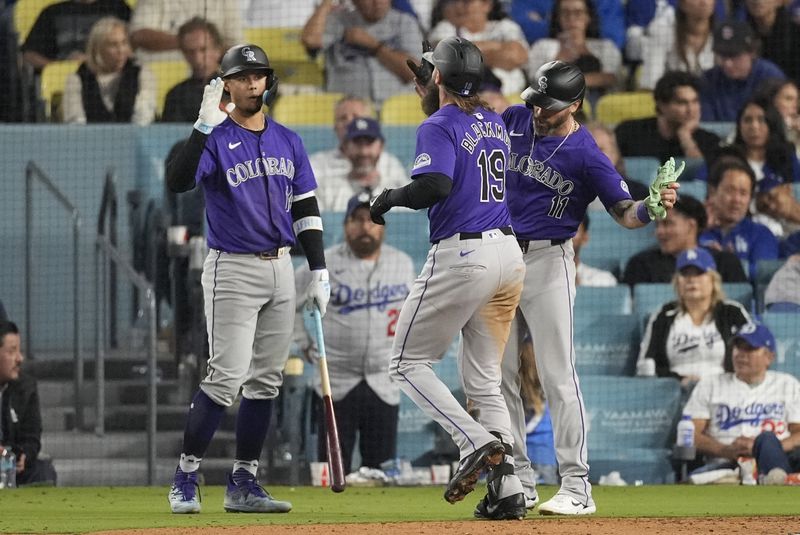 Colorado Rockies designated hitter Charlie Blackmon (19) celebrates with Jake Cave (11) and Ezequiel Tovar (14) after hitting a home run during the ninth inning of a baseball game against the Los Angeles Dodgers in Los Angeles, Saturday, Sept. 21, 2024. Cave also scored. (AP Photo/Ashley Landis)