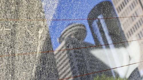 A parked car at John Portman Blvd. and Peachtree Center Avenue reflects a pollinated view of the Atlanta skyline from the back window in April 2013. JOHN SPINK / JSPINK@AJC.COM