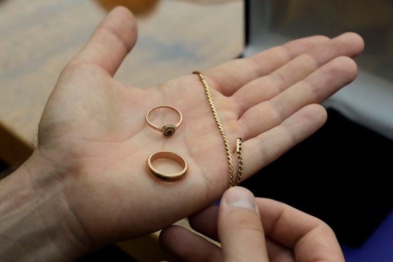 A relative shows golden jewelry that was confiscated by Nazi Germans from Zofia Strusińska and her sister Józefa Skórka, who were captured by Nazi troops during Warsaw Uprising in 1944 and taken to a forced labor camp. Their seized items that had been stored at Germany's Arolsen Archives, were returned to their relatives in a ceremony in Warsaw, Poland, on Tuesday, Sept. 10, 2024, in which 10 other families also had belongings of their relatives returned. (AP Photo/Czarek Sokolowski)