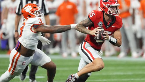 Georgia quarterback Carson Beck (15) escapes from Clemson defensive end T.J. Parker (3) during the second half of an NCAA college football game Aug. 31, 2024, in Atlanta. (AP Photo/John Bazemore)