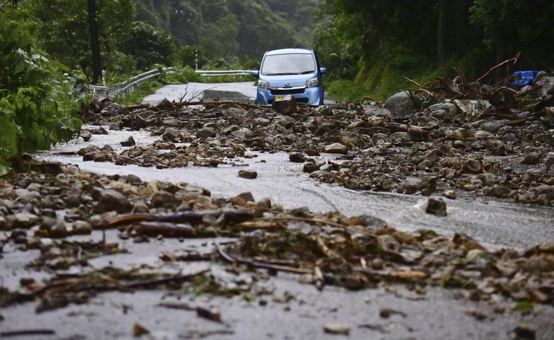 A car is blocked by rocks covering a road, after heavy rain in Wajima, Ishikawa prefecture, Saturday, Sept. 21, 2024. (Kyodo News via AP)