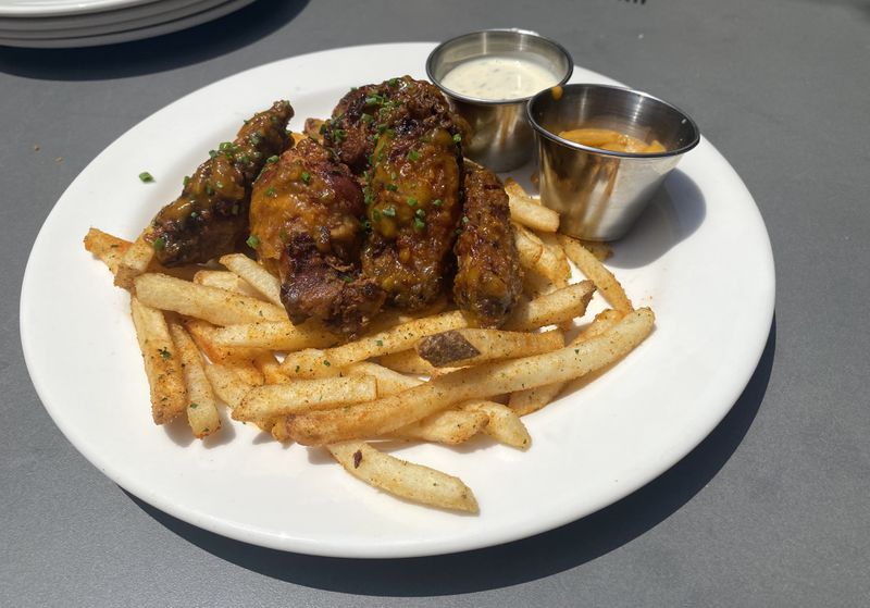 The "everything" wings at Marcus Bar & Grille are served over fries. Ligaya Figueras/ligaya.figueras@ajc.com