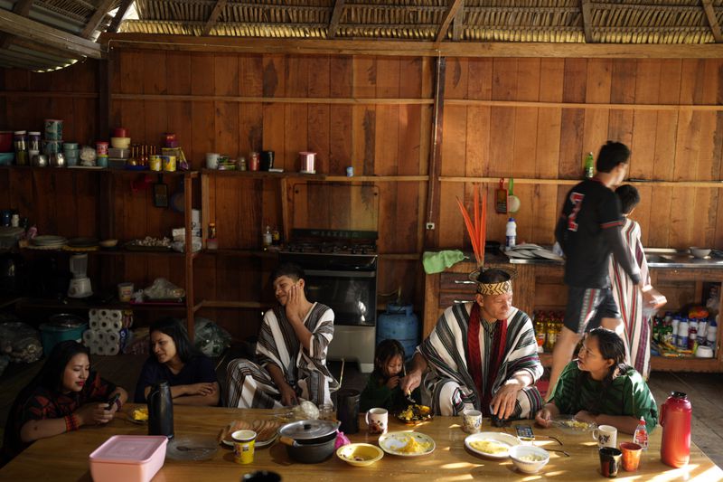 Ashaninka Indigenous family of Wewito Piyako and his wife Auzelina Ashaninka, right, have breakfast at their home in the Apiwtxa village, Acre state, Brazil, Saturday, June 22, 2024. (AP Photo/Jorge Saenz)