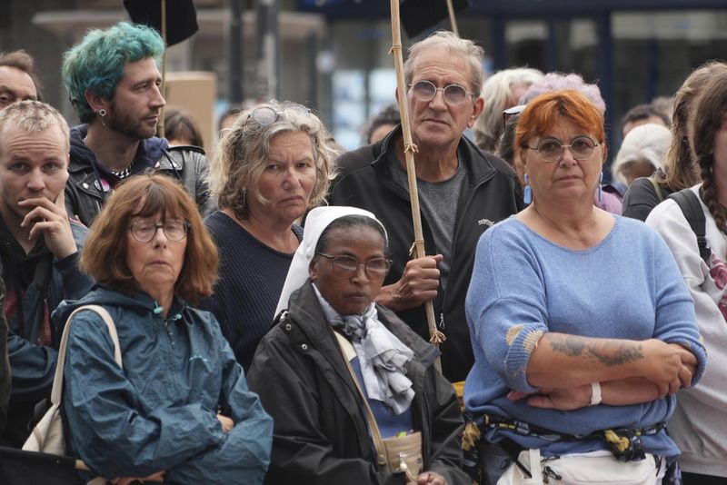 People gather in Calais, France, Wednesday, Sept 4, 2024, to pay homage to the migrants who drowned when their small inflatable boat was ripped apart in the English channel on Tuesday. (AP Photo/Nicolas Garriga)