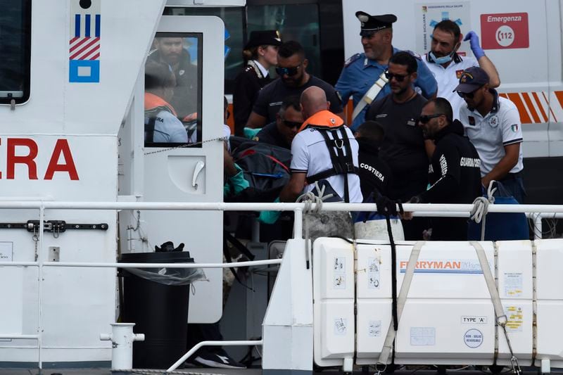 Italian Firefighters scuba divers bring ashore in a bag the body of one of the victims of the UK flag vessel Bayesian, Wednesday, Aug. 21, 2024. The sail yacht was hit by a violent sudden storm and sunk early Monday, while at anchor off the Sicilian village of Porticello near Palermo, in southern Italy. (AP Photo/Salvatore Cavalli)