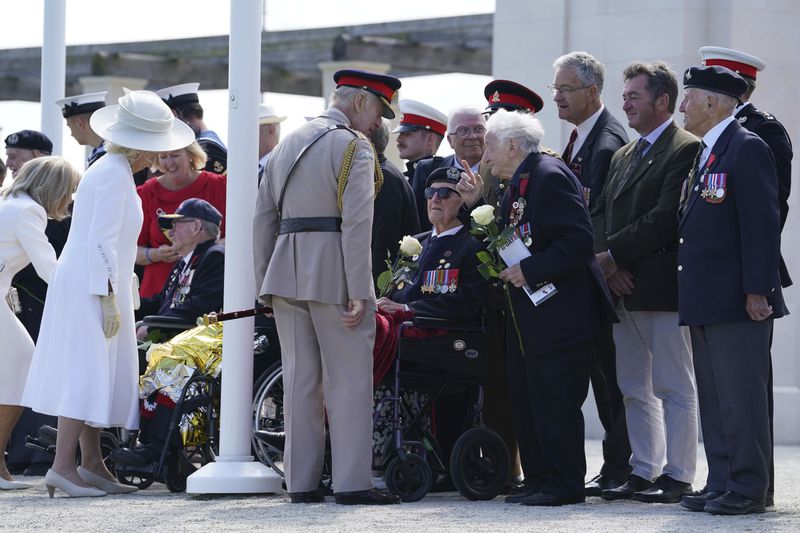 Britain's King Charles III and Queen Camilla speak to D-Day veterans, including Albert Keir, third right, and Stan Ford, fourth right, following the UK national commemorative event for the 80th anniversary of D-Day, held at the British Normandy Memorial in Ver-sur-Mer, Normandy, France, Thursday June 6, 2024. (Gareth Fuller, Pool Photo via AP)