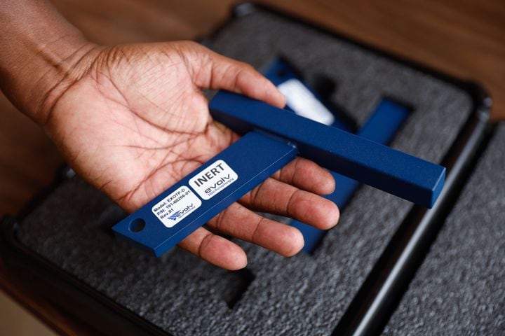 An analyst with the DeKalb County Safe Schools program holds a test tool used for training for the Evolv weapons detection system at Adams Stadium on Thursday, Aug. 15, 2024. The system has already been implemented in many DeKalb schools and will be expanding to football stadiums. (Natrice Miller/ AJC)