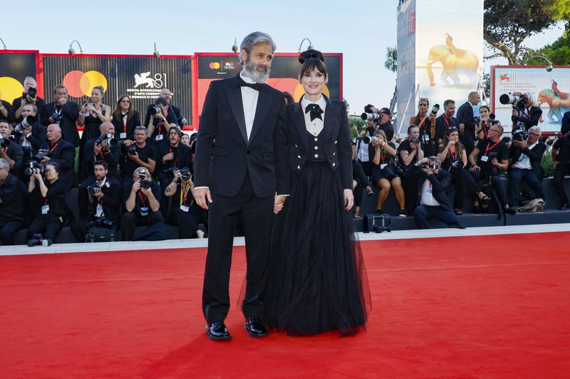 Scott Mackinlay Hahn, left, and Winona Ryder pose for photographers upon arrival for the premiere of the film 'Beetlejuice Beetlejuice' and the opening ceremony of the 81st edition of the Venice Film Festival in Venice, Italy, on Wednesday, Aug. 28, 2024. (Photo by Joel C Ryan/Invision/AP)