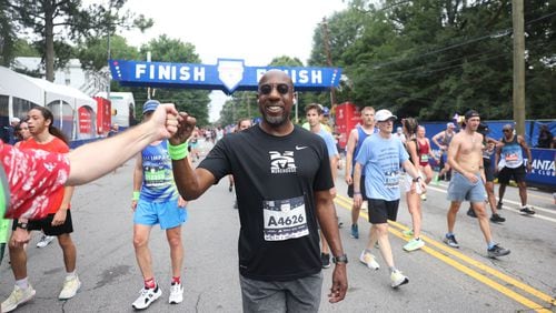 Sen. Raphael Warnock celebrates at the finish of the 54th running of the Atlanta Journal-Constitution Peachtree Road Race in Atlanta on Tuesday, July 4, 2023.   (Jason Getz / Jason.Getz@ajc.com)