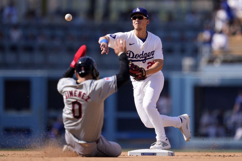 Cleveland Guardians' Andres Gimenez, left, is forced out at second by Los Angeles Dodgers shortstop Tommy Edman as Edman throws out Jose Ramirez at first during the ninth inning of a baseball game, Sunday, Sept. 8, 2024, in Los Angeles. (AP Photo/Mark J. Terrill)