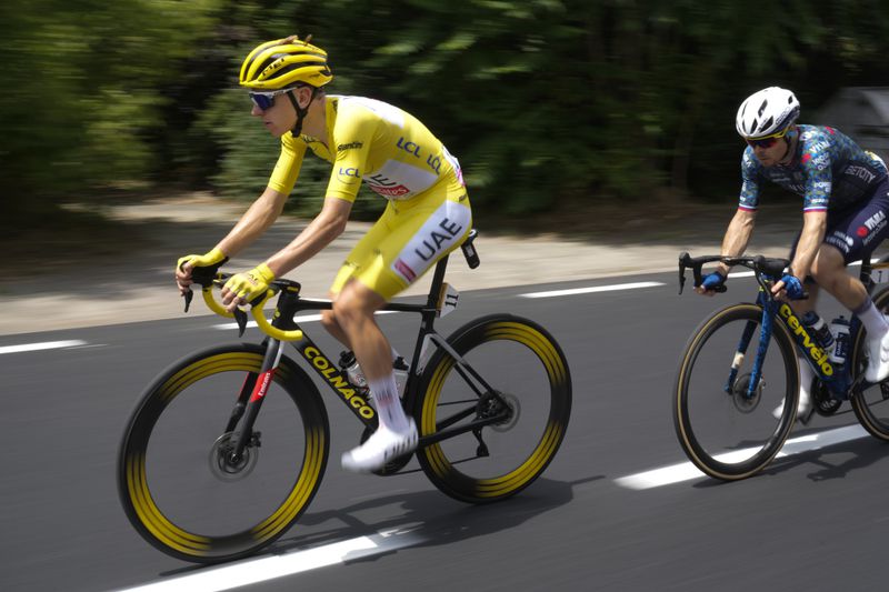Slovenia's Tadej Pogacar, wearing the overall leader's yellow jersey, is followed by Slovenia's Jan Tratnik during the third stage of the Tour de France cycling race over 230.8 kilometers (143.4 miles) with start in Piacenza and finish in Turin, Italy, Monday, July 1, 2024. (AP Photo/Jerome Delay)