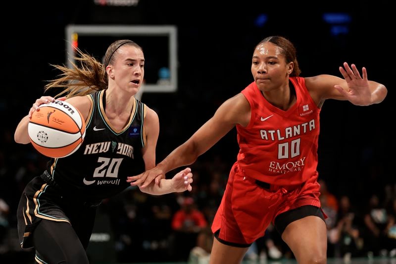 New York Liberty guard Sabrina Ionescu (20) drives past Atlanta Dream forward Naz Hillmon during the first half of a first-round WNBA basketball playoff game, Tuesday, Sept. 24, 2024, in New York. (AP Photo/Adam Hunger)