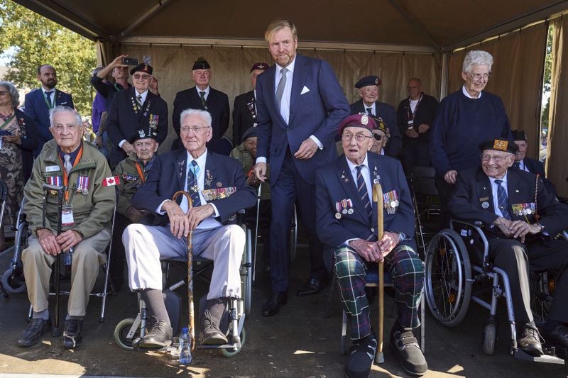 Kink Willem Alexander of the Netherlands, center, meets some surviving veterans in Ginkel Heath Netherlands, Saturday, Sept. 21, 2024, to mark the 80th anniversary of an audacious by unsuccessful World War II mission codenamed Market Garden to take key bridges in the Netherlands. (AP Photo/Phil Nijhuis)