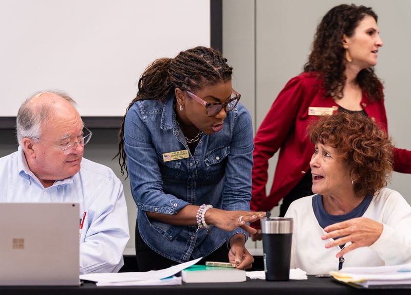 Cobb County Board of Elections Chair Tori Silas, center, and board member Debbie Fisher talk before the board's meeting Saturday in Marietta. Seeger Gray/AJC