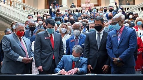 Gov. Brian Kemp signs into law House Bill 426, hate-crimes legislation, on the last day of the legislative session Friday at the Georgia Capitol. (Hyosub Shin / Hyosub.Shin@ajc.com)