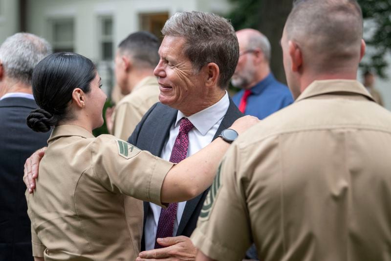 Bart Collart, center, visits with friends of his son, Cpl. Spencer Collart, who was posthumously presented the USMCs highest non-combat medal, The Navy and Marine Corps Medal, during a ceremony on Monday, Sept. 16, 2024 in Washington. (AP Photo/Kevin Wolf)