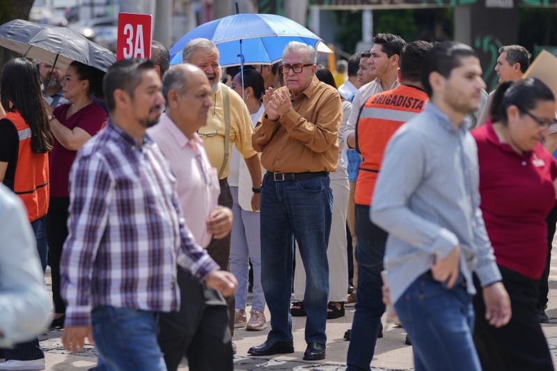 Sinaloa state Gov. Ruben Rocha, center, participates in an annual earthquake drill in Culiacan, Mexico, Thursday, Sept. 19, 2024. (AP Photo/Eduardo Verdugo)