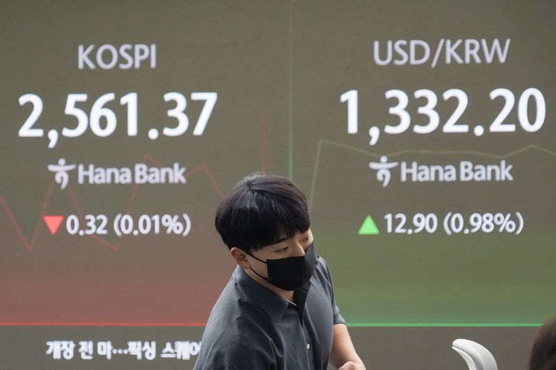 A currency trader watches monitors near a screen showing the Korea Composite Stock Price Index (KOSPI), left, and the foreign exchange rate between U.S. dollar and South Korean won at the foreign exchange dealing room of the KEB Hana Bank headquarters in Seoul, South Korea, Friday, Oct. 4, 2024. (AP Photo/Ahn Young-joon)