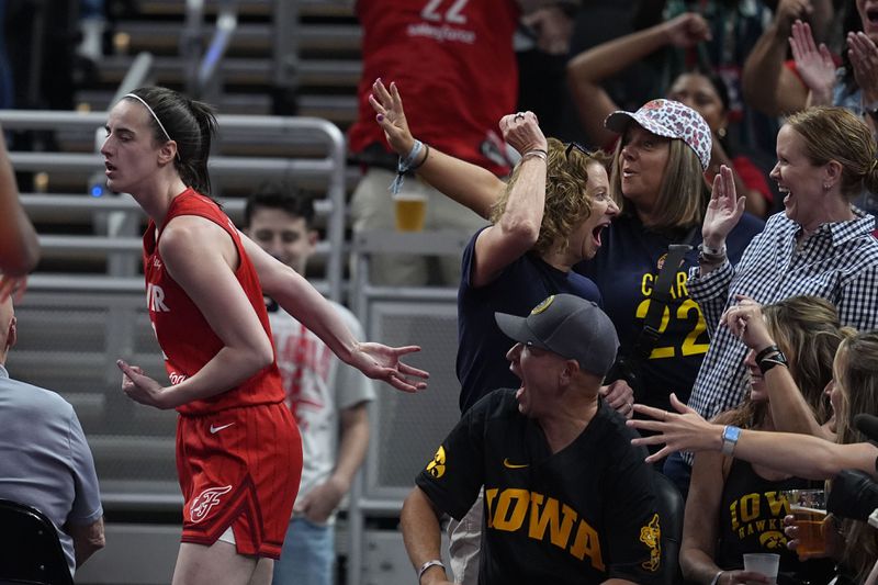 Indiana Fever guard Caitlin Clark, left, reacts with fans after hitting a shot and getting fouled during the first half of a WNBA basketball game against the Phoenix Mercury, Friday, Aug. 16, 2024, in Indianapolis. (AP Photo/Darron Cummings)