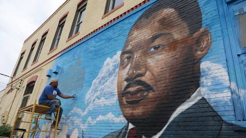 Kevin “Scene” Lewis works on a mural of Rev. Martin Luther King Jr. on Wednesday, Sept. 11, 2024, off of Martin Luther King Jr. Boulevard in Macon, Georgia. The mural will depict King as well as cherry blossoms and Zion Baptist Church, the last place King visited in Macon before his assassination in 1968. (Photo Courtesy of Katie Tucker/The Telegraph)