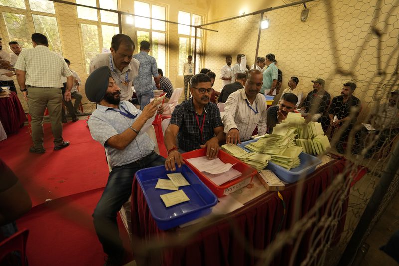 Electoral counting officials count postal ballots at a counting centre for the assembly election in Jammu, India, Tuesday, Oct. 8,2024. (AP Photo/Channi Anand)