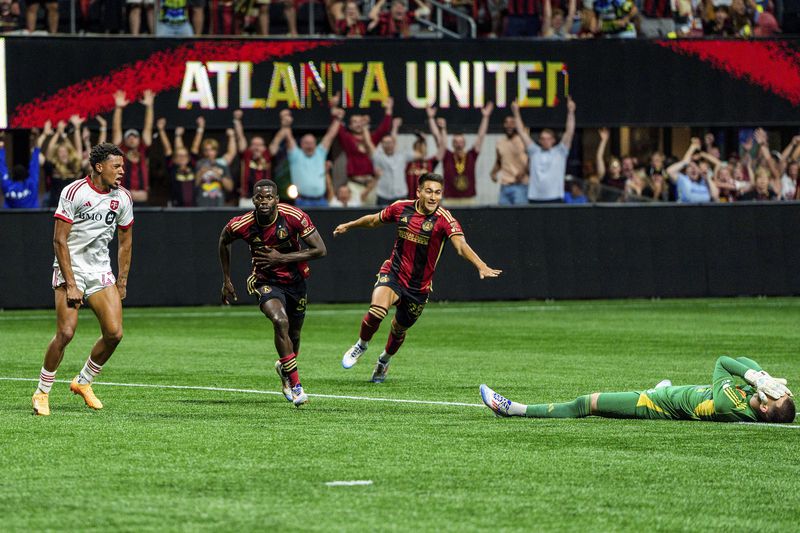 Atlanta United forward Jamal Thiaré, second from left, and forward Tyler Wolff, third from left, celebrate after the winning goal as Toronto FC midfielder Kosi Thompson, left, and goalkeeper Luka Gavran, right, react during the second half of an MLS soccer match, Saturday, June 29, 2024, in Atlanta. (AP Photo/Danny Karnik)