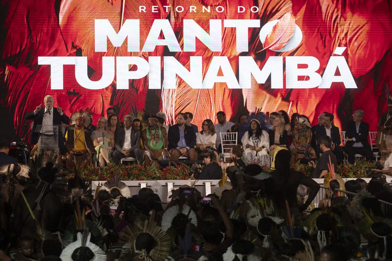 Brazil's President Luiz Inacio Lula da Silva, left, speaks during a ceremony celebrating the return of the Indigenous Tupinamba people's sacred cloak to Brazil, in Rio de Janeiro, Thursday, Sept. 12, 2024. The garment, made from bird feathers and plant fibers, was repatriated to Brazil after having spent more than 300 years in the National Museum of Denmark. (AP Photo/Bruna Prado)