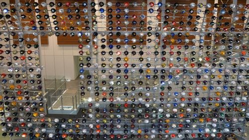 A wall of helmets greets fans at the College Football Hall of Fame. (AJC file photo by Brant Sanderlin)