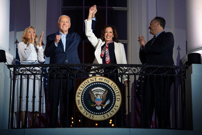 First lady Jill Biden and second gentleman Douglass Emhoff watch as President Joe Biden raises the hand of Vice President Kamala Harris while they view the Independence Day firework display over the National Mall from the balcony of the White House, Thursday, July 4, 2024, in Washington. (AP Photo/Evan Vucci)