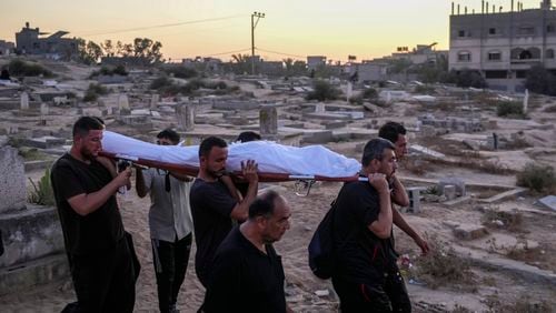 Palestinian mourners carry their loved one for burial at the cemetery in Deir al-Balah, Gaza Strip, Friday, Aug. 9, 2024. (AP Photo/Abdel Kareem Hana)