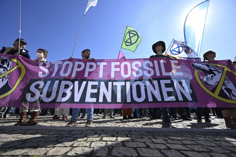 Demonstrators walk across Munich's Königsplatz with a placard reading "Stop fossil subsidies" during Fridays for Future protest in Munich, Germany, Friday Sept. 20, 2024. (Felix Hörhager/dpa via AP)