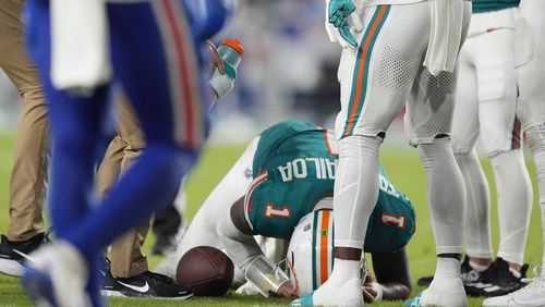 Miami Dolphins quarterback Tua Tagovailoa (1) is assisted on the field during the second half of an NFL football game against the Buffalo Bills, Thursday, Sept. 12, 2024, in Miami Gardens, Fla. (AP Photo/Rebecca Blackwell)