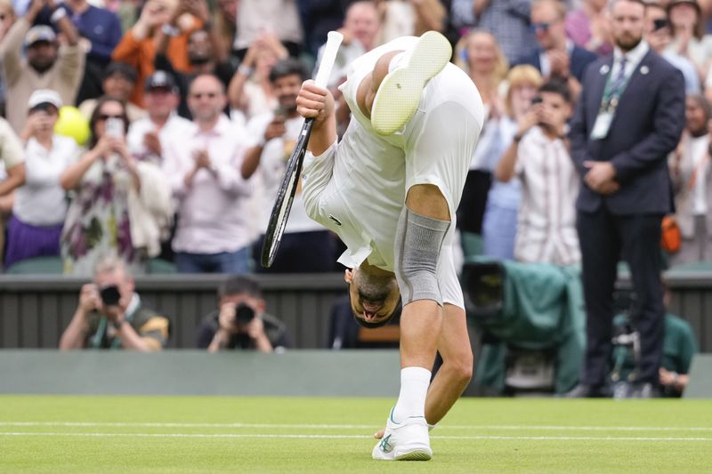 Serbia's Novak Djokovic touches the court surface as he celebrates after defeating Vit Kopriva of the Czech Republic in their first round match at the Wimbledon tennis championships in London, Tuesday, July 2, 2024. (AP Photo/Kirsty Wigglesworth)