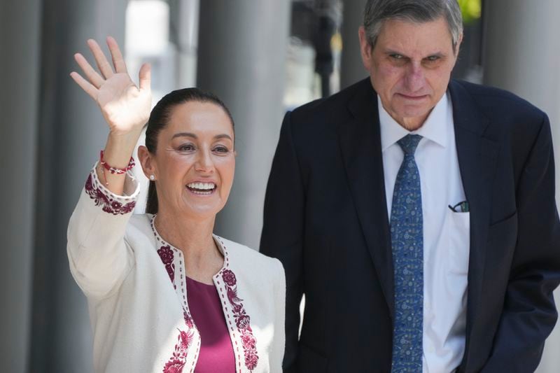 FILE - President-elect Claudia Sheinbaum, accompanied by husband Jesus Maria Tarriba, waves as she arrives to a ceremony to certify her as the winner of the presidential election, in Mexico City, Aug. 15, 2024. Sheinbaum, a climate scientist and former Mexico City mayor, will be sworn in as Mexico’s first woman president on Oct. 1. (AP Photo/Fernando Llano, File)