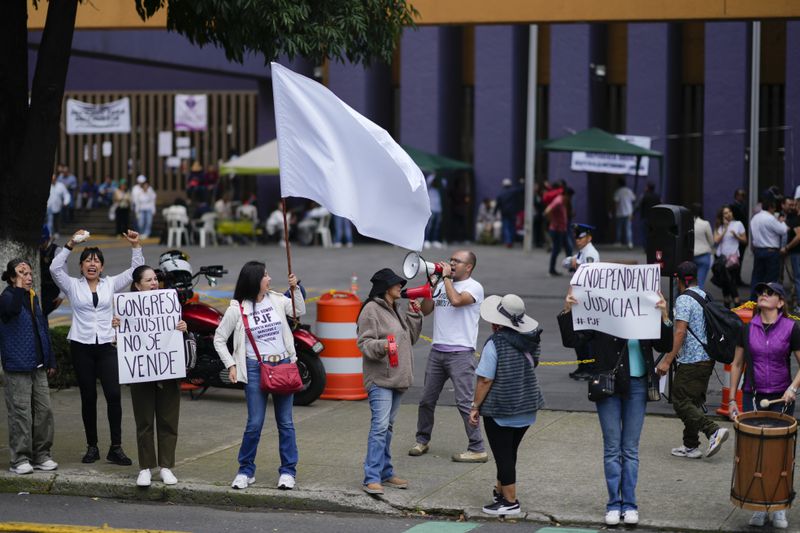 Unionized federal court workers hold signs and shout slogans as they strike over reforms that would make all judges stand for election, outside a federal court in Mexico City, Tuesday, Aug. 20, 2024. (AP Photo/Eduardo Verdugo)