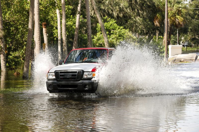 A truck drives through a flooded street around the Sunset Park neighborhood as Hurricane Helene makes its way toward the Florida panhandle on Thursday, Sept. 26, 2024, in Tampa, Fla. (Jefferee Woo/Tampa Bay Times via AP)