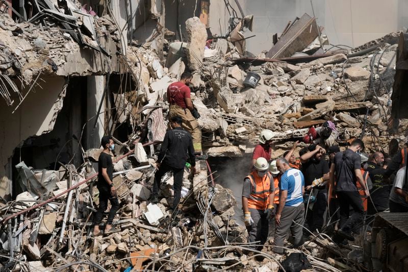 Emergency workers clear the rubble at the site of Friday's Israeli strike in Beirut's southern suburbs, Saturday, Sept. 21, 2024. (AP Photo/Bilal Hussein)