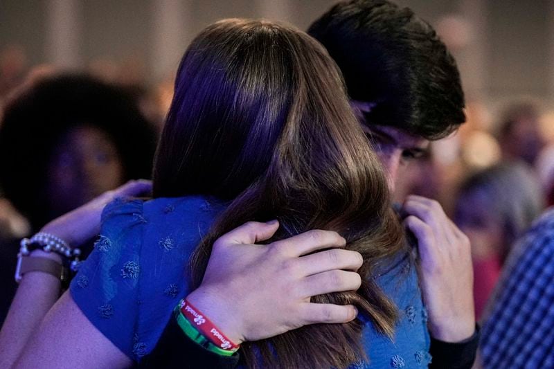 An Apalachee High School student is embraced during a Sunday service at Bethlehem Church, Sunday, Sept. 8, 2024, in Bethlehem, Ga. Colt Gray, 14, has been charged with murder over the killing of two students and two teachers at Apalachee High School in Barrow County, outside Atlanta, on Wednesday. (AP Photo/Mike Stewart)