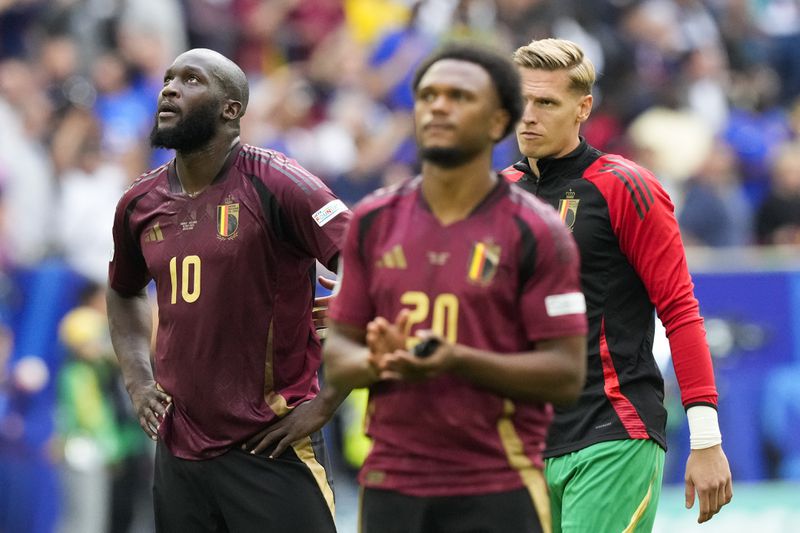 Belgium's Romelu Lukaku, left, and Belgium's Lois Openda, center, react after a 1-0 loss to France in a round of sixteen match between France and Belgium at the Euro 2024 soccer tournament in Duesseldorf, Germany, Monday, July 1, 2024. (AP Photo/Frank Augstein)