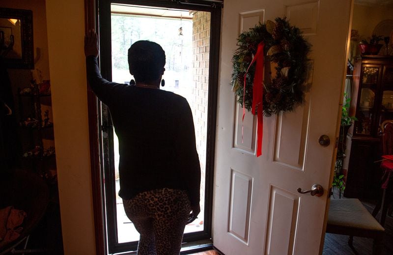 A client of the federal Housing Opportunities for Persons with AIDS program looks out the front door of the Ellenwood house where she was staying on Sunday, December 23, 2021.  She is homeless after her case fell through the cracks of the city of Atlanta-run program. STEVE SCHAEFER FOR THE ATLANTA JOURNAL-CONSTITUTION