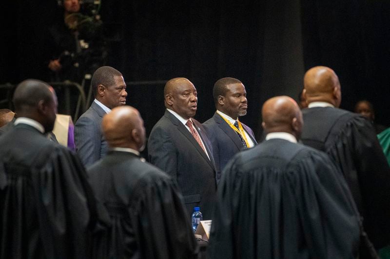 South African President Cyril Ramaphosa, center, sings the national anthem before being sworn is as a member of Parliament ahead of an expected vote by lawmakers to decide if he is reelected as leader of the country in Cape Town, South Africa, Friday, June 14, 2024. (AP Photo/Jerome Delay)