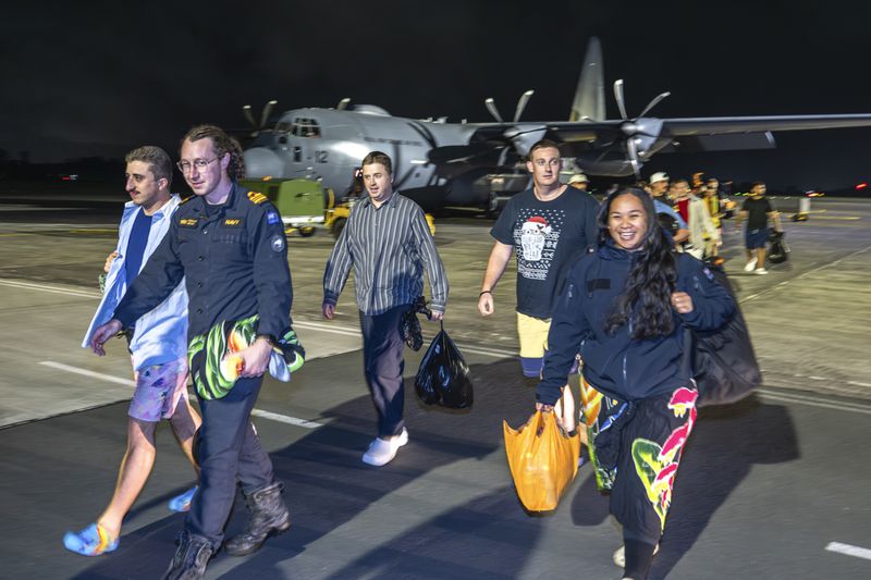 In this image released by New Zealand Defence Force (NZDF), crew of the HMNZS Manawanui that sank in Samoa on Oct. 6, 2024, walk from their plane after landing at RNZAF Base Auckland, from Samoa, in Whenuapai, New Zealand, Monday, Oct. 7, 2024. (Petty Officer Chris Weissenborn/NZDF via AP)